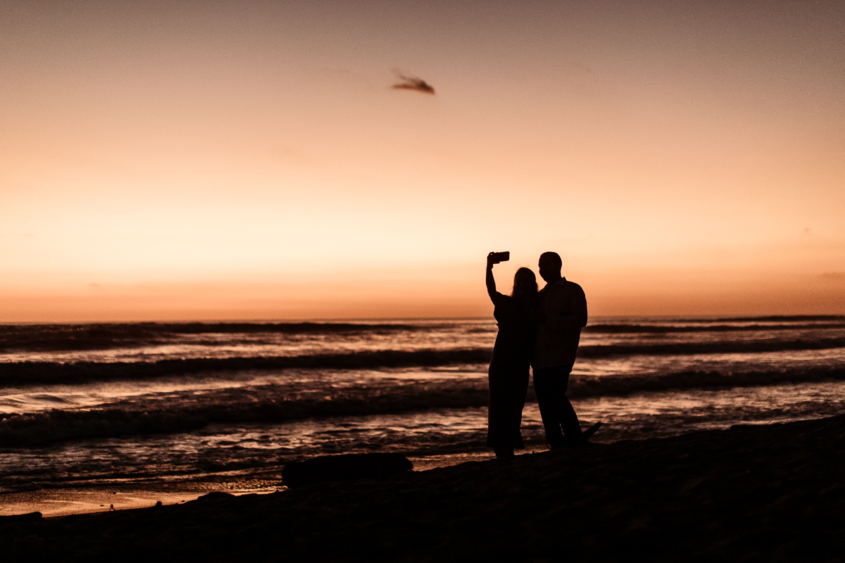 couple taking photo at sunset